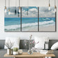 Three-panel canvas wall art featuring tropical beach scene with turquoise water, displayed in a modern living room above seating.