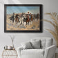 Impressionist western action scene by Frederic Remington in an ornate black frame with gilded inner detail displayed in a bright interior setting.