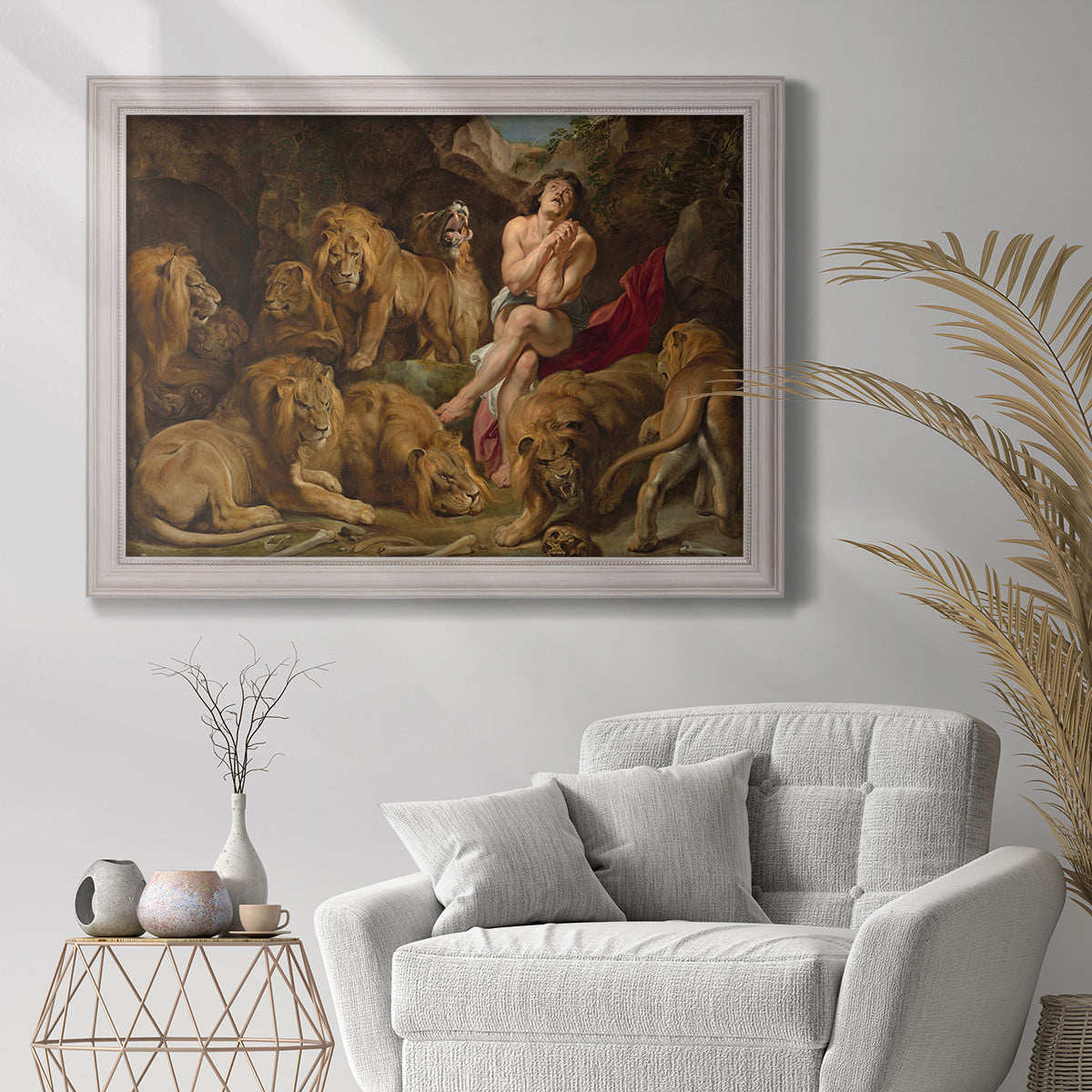 Dramatic biblical painting of Daniel with lions by Peter Paul Rubens in an ornate weathered white frame displayed in a bright interior setting.