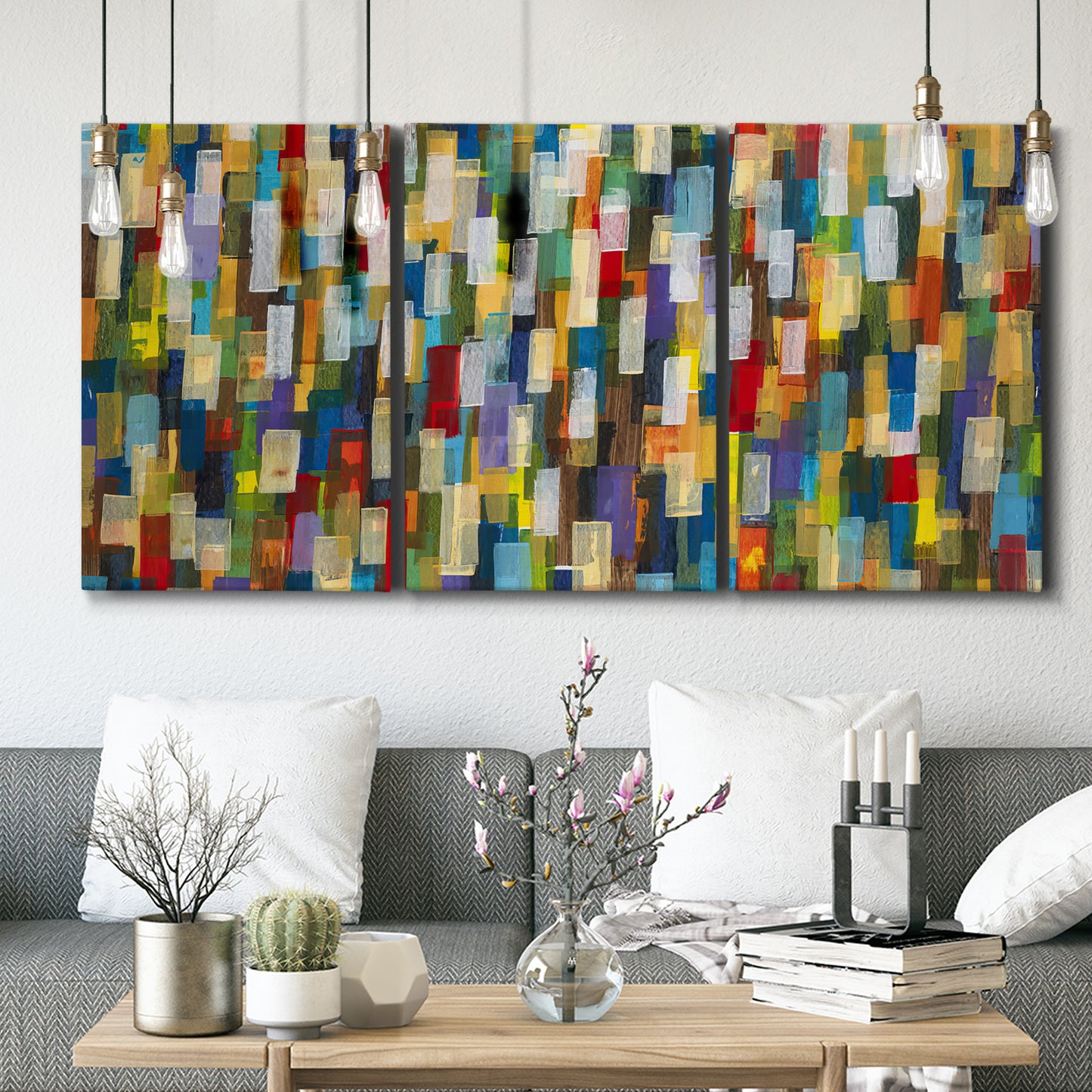 Three-panel canvas wall art featuring colorful confetti style abstraction, displayed in a modern living room above seating.