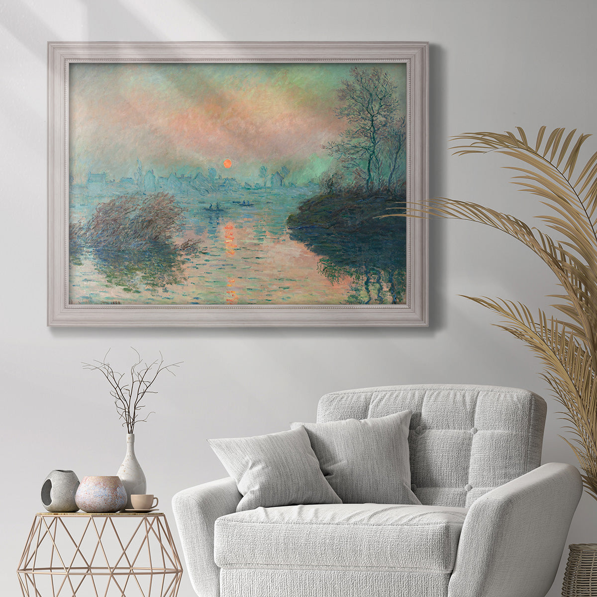 Impressionist winter river sunset scene by Claude Monet in an ornate weathered white frame displayed in a bright interior setting.