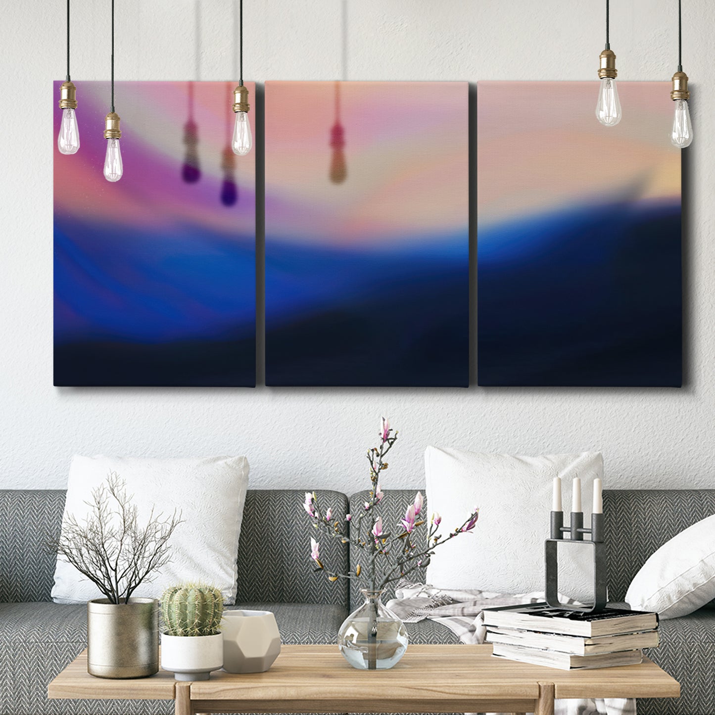 Three-panel canvas wall art featuring smooth abstract sunset color gradient, displayed in a modern living room above seating.