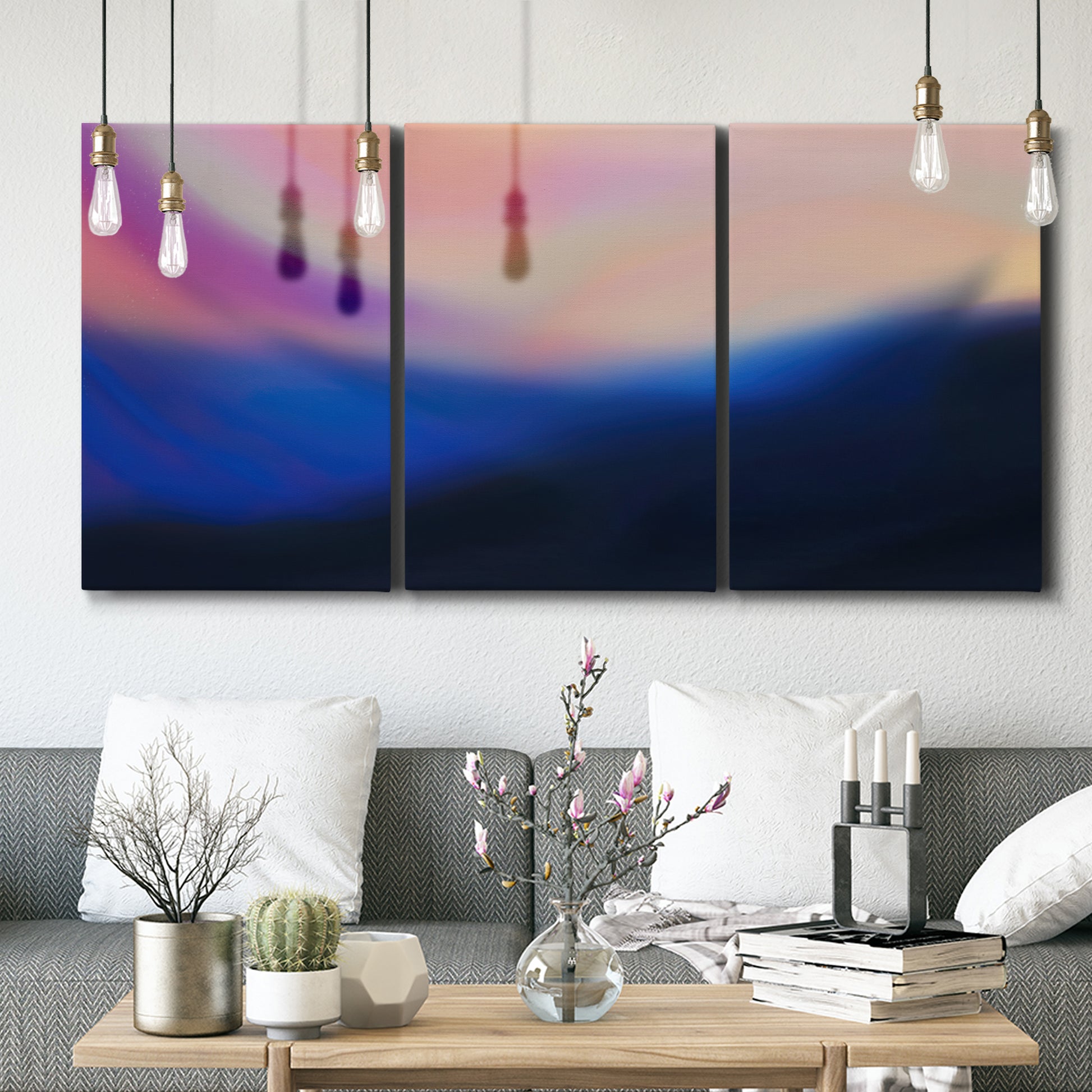 Three-panel canvas wall art featuring smooth abstract sunset color gradient, displayed in a modern living room above seating.