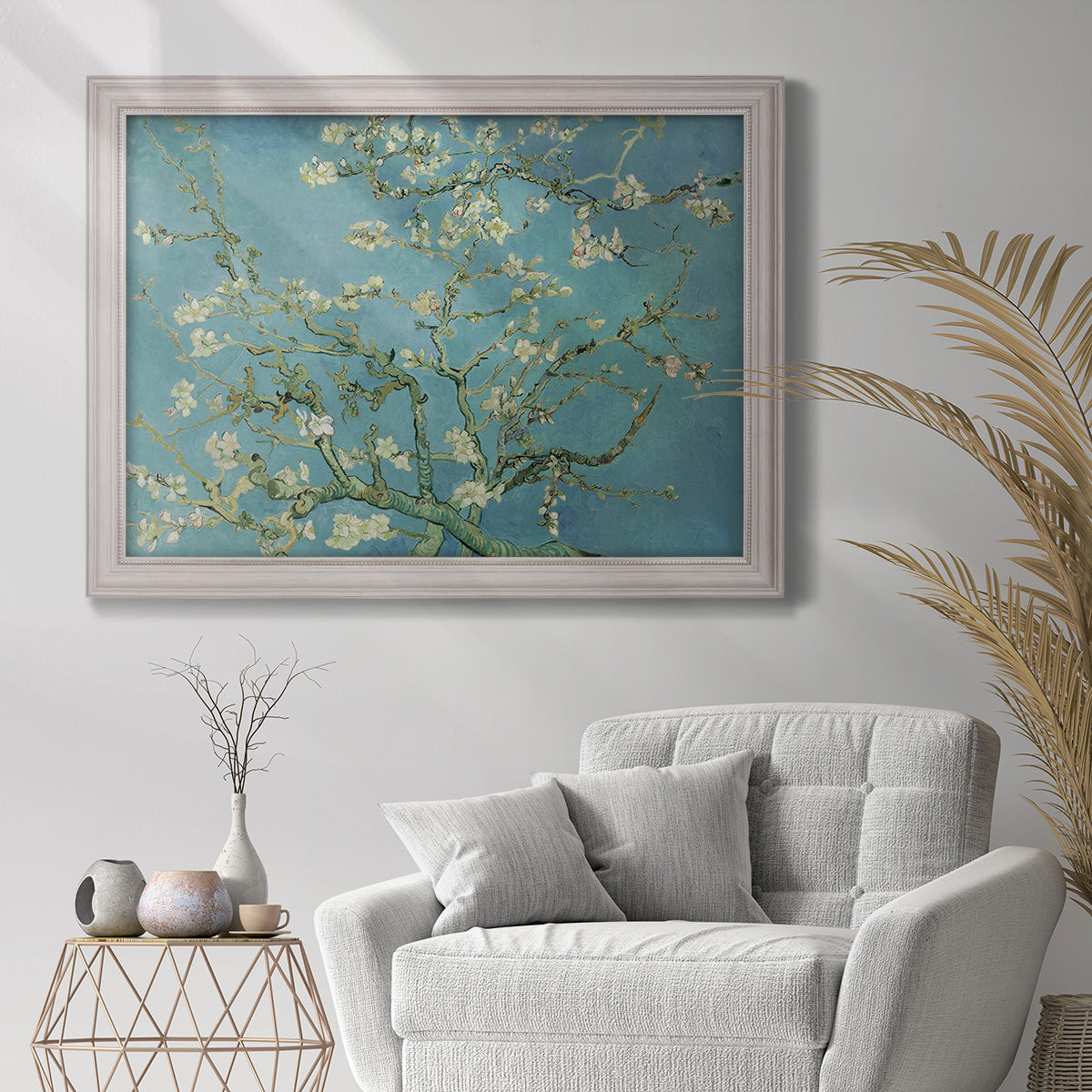 Impressionist flowering almond branch painting by Vincent van Gogh in an ornate weathered white frame displayed in a bright interior setting.