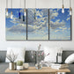 Three-panel canvas wall art featuring whimsical cloud filled sky landscape, displayed in a modern living room above seating.