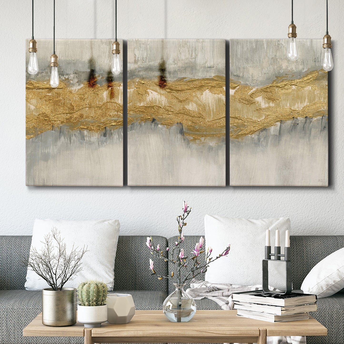 Three-panel canvas wall art featuring flowing abstract golden tones, displayed in a modern living room above seating.
