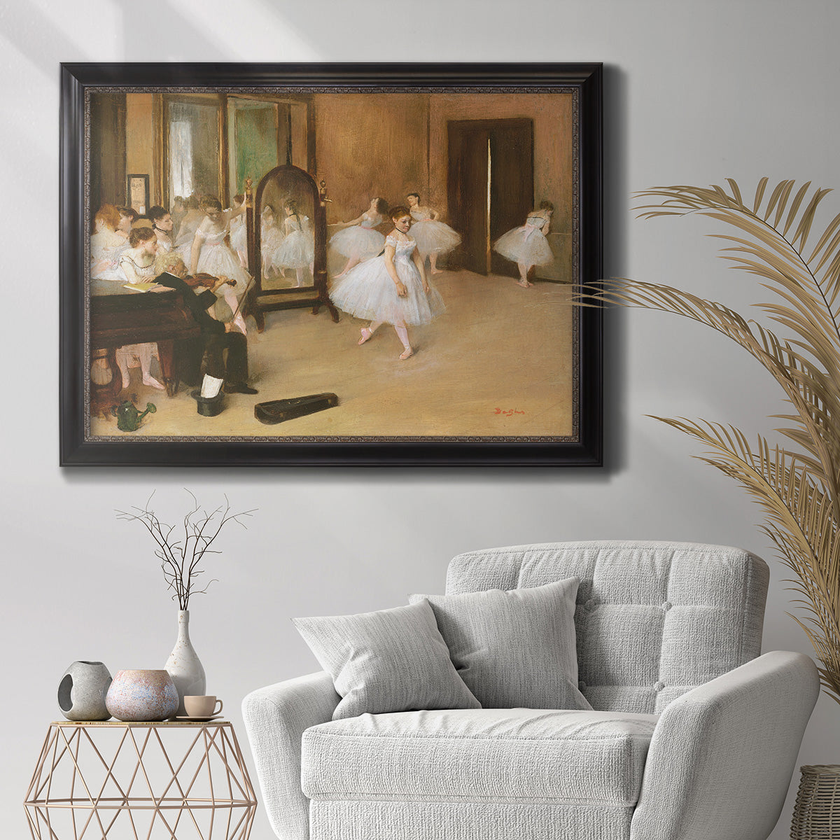 Impressionist dance class interior scene by Edgar Degas in an ornate black frame with gilded inner detail displayed in a bright interior setting.