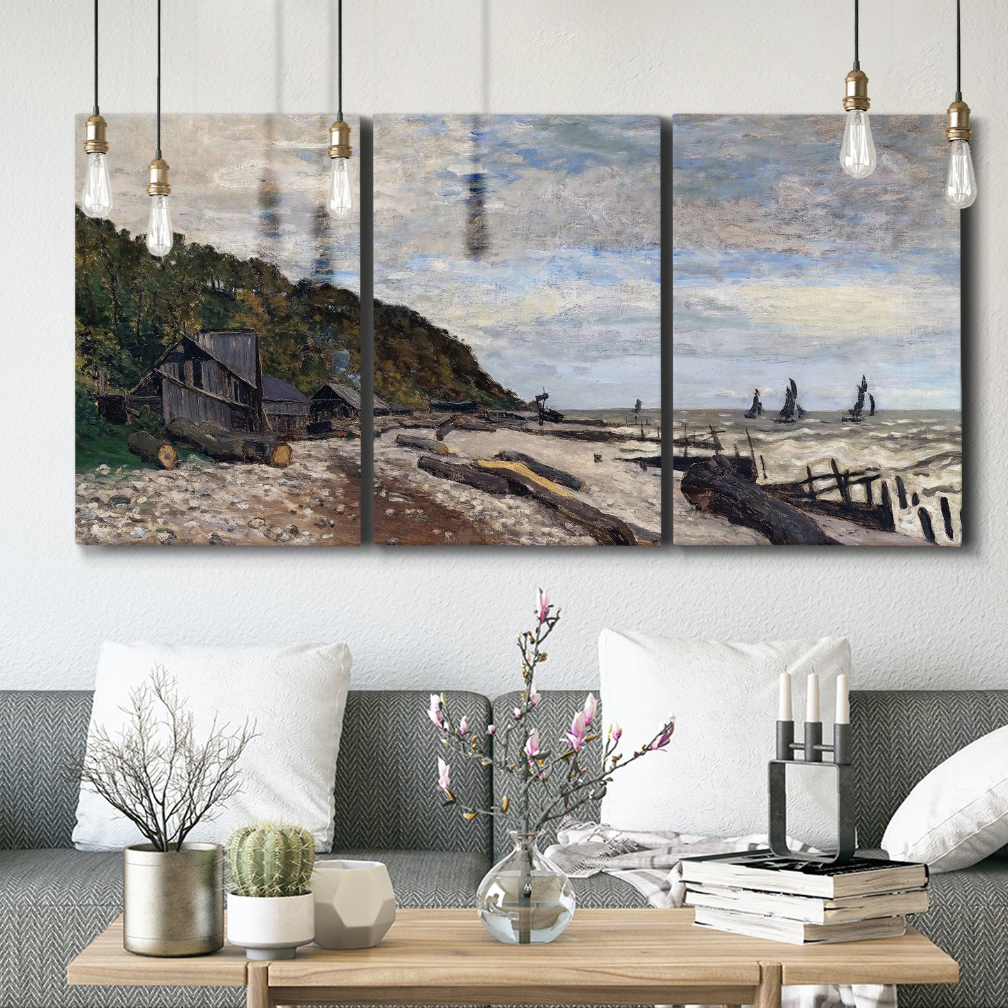 Three-panel canvas wall art featuring open sea along rocky shore, displayed in a modern living room above seating.