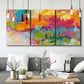 Three-panel canvas wall art featuring expressive abstract sunset tones, displayed in a modern living room above seating.