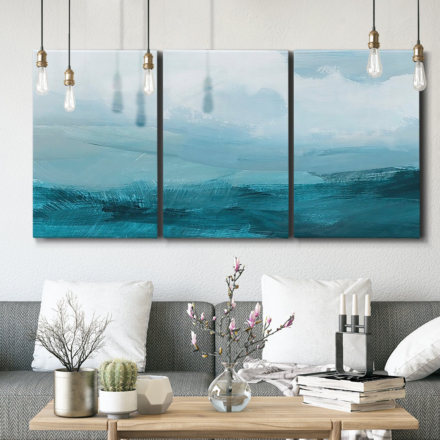 Three-panel canvas wall art featuring vertical coastal elements with rising light, displayed in a modern living room above seating.