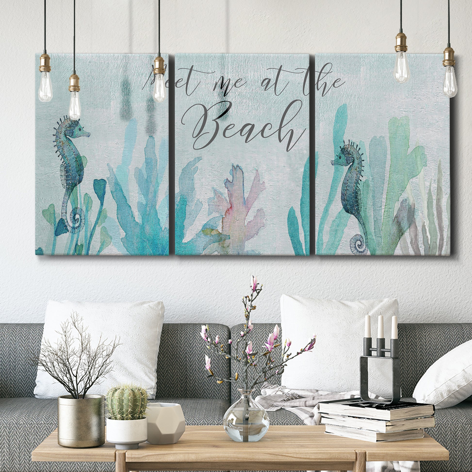 Three-panel canvas wall art featuring coastal typography with seahorses, displayed in a modern living room above seating.