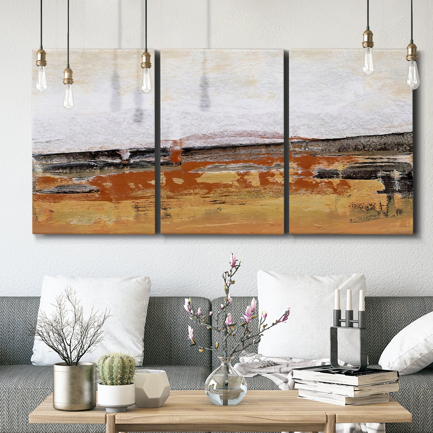Three-panel canvas wall art featuring abstract bridge landscape in ochre, displayed in a modern living room above seating.