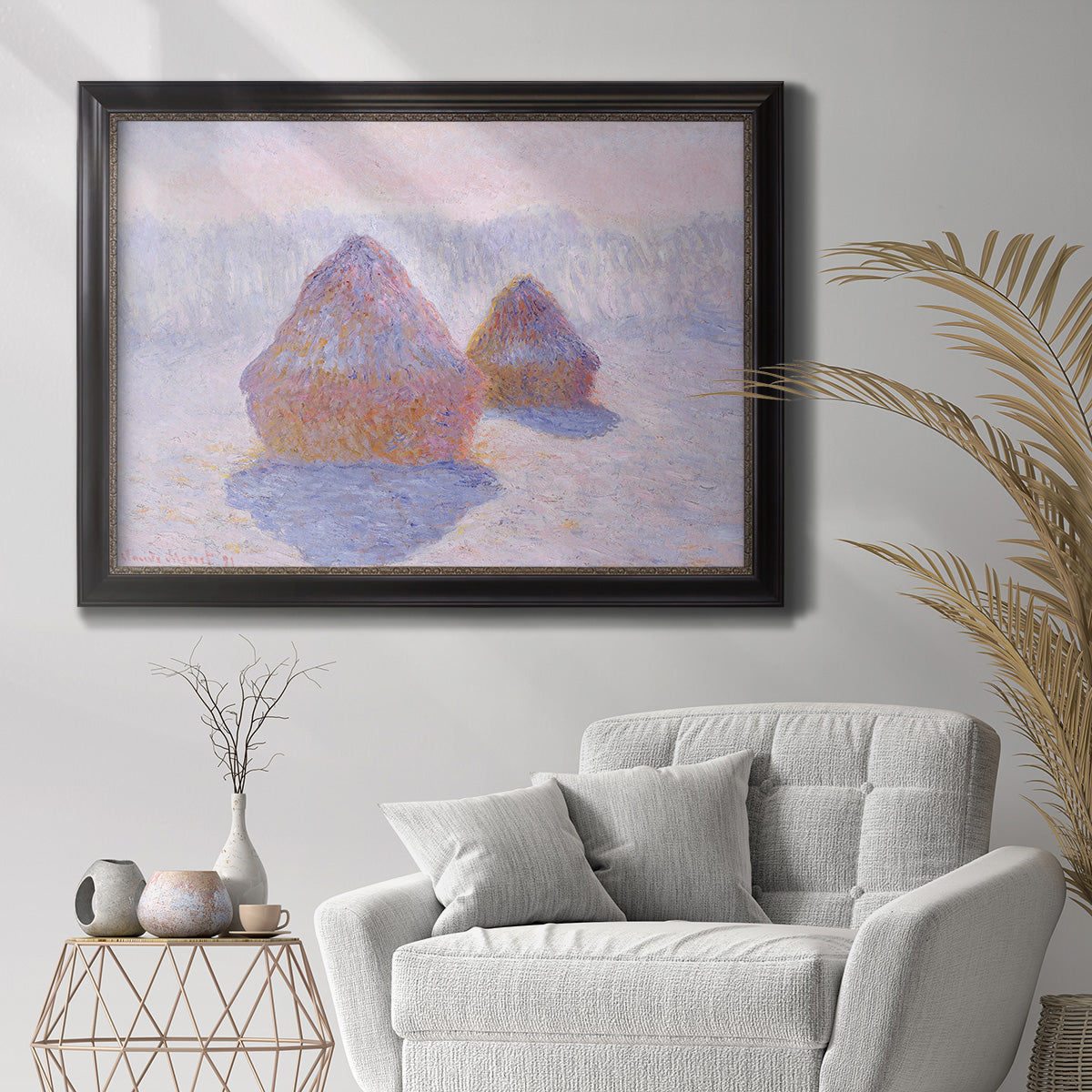 Impressionist winter haystack scene with sunlight by Claude Monet in an ornate black frame with gilded inner detail displayed in a bright interior setting.
