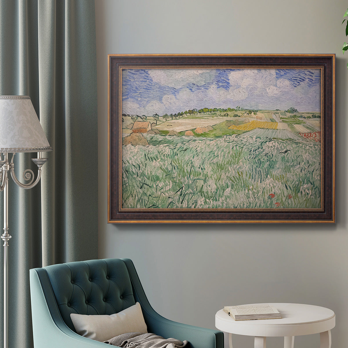 Impressionist countryside landscape near Auvers by Vincent van Gogh in an ornate bronzed mahogany wood frame displayed in a bright interior setting.