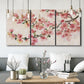 Three-panel canvas wall art featuring blooming cherry blossom branches, displayed in a modern living room above seating.