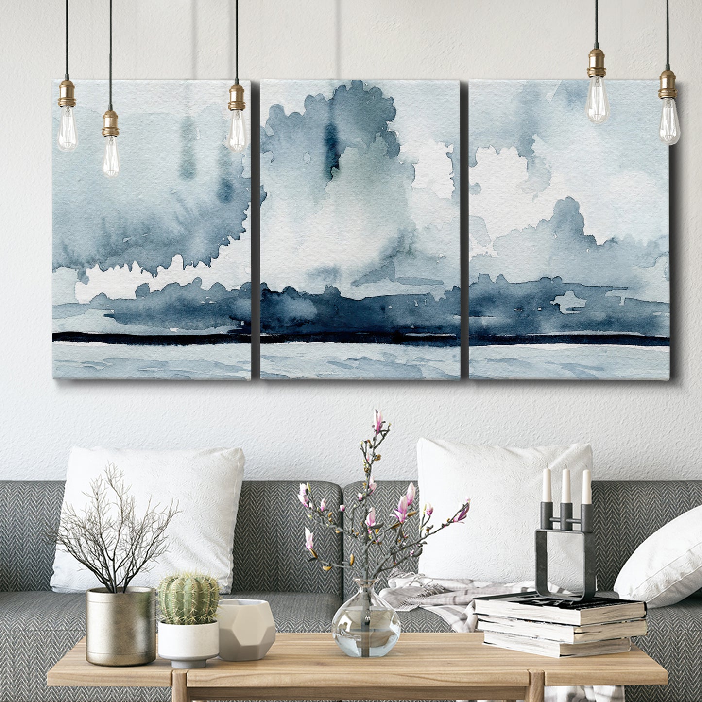 Three-panel canvas wall art featuring abstract rainstorm watercolor, displayed in a modern living room above seating.