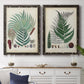 Set of two black barnwood framed canvas prints depicting a coordinated art pair of vintage fern specimens with botanical details rendered as natural-history fern plates above a dining room sideboard.