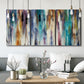 Three-panel canvas wall art featuring abstract shifting color forms, displayed in a modern living room above seating.