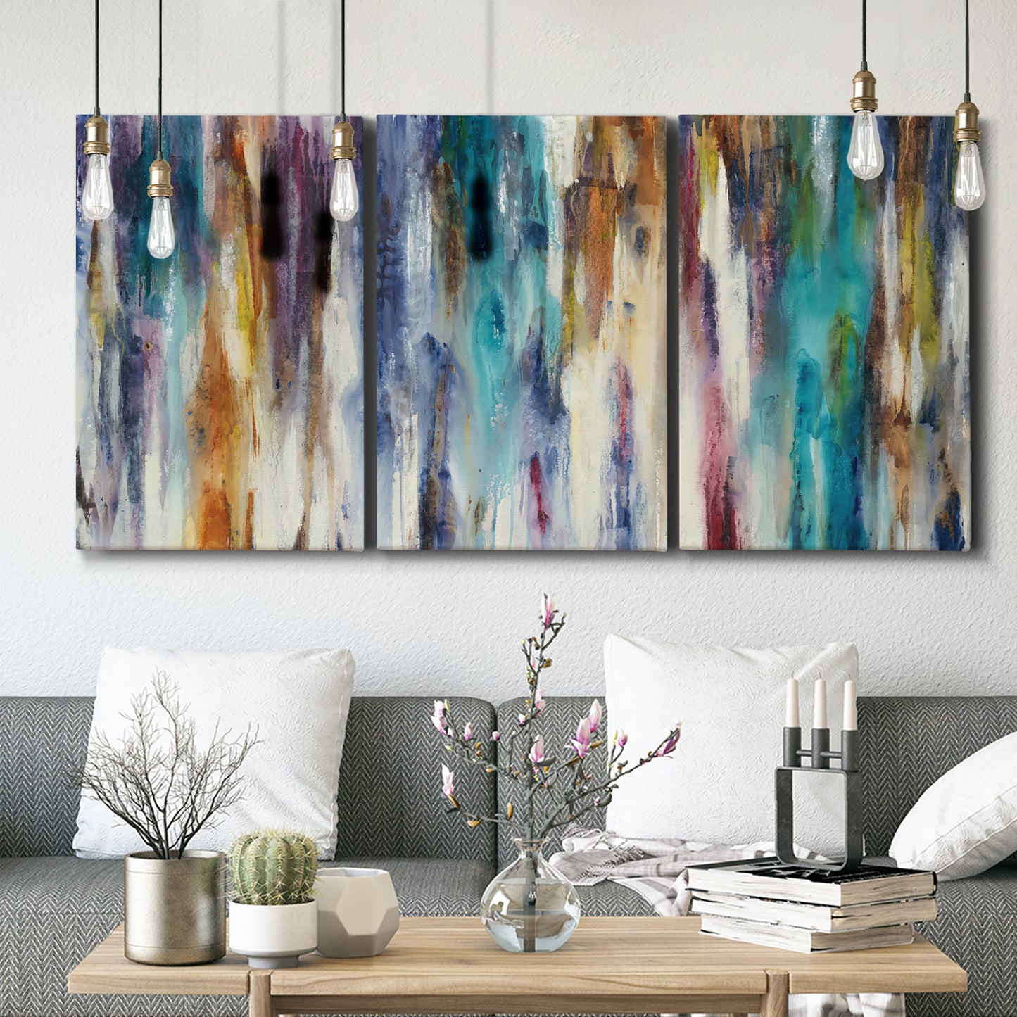 Three-panel canvas wall art featuring abstract shifting color forms, displayed in a modern living room above seating.