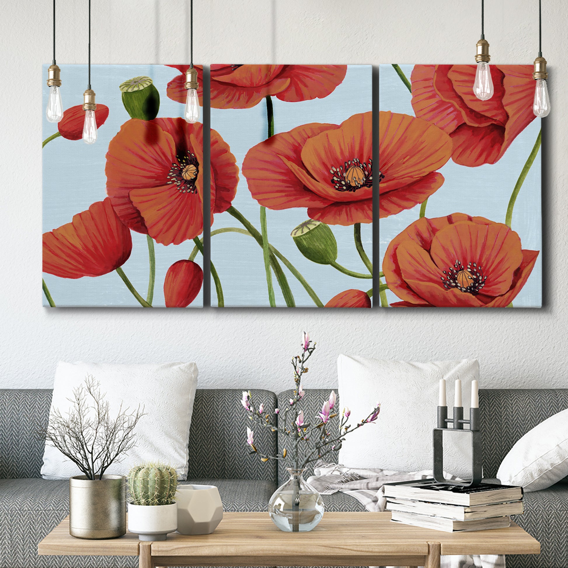 Three-panel canvas wall art featuring red poppies in motion, displayed in a modern living room above seating.
