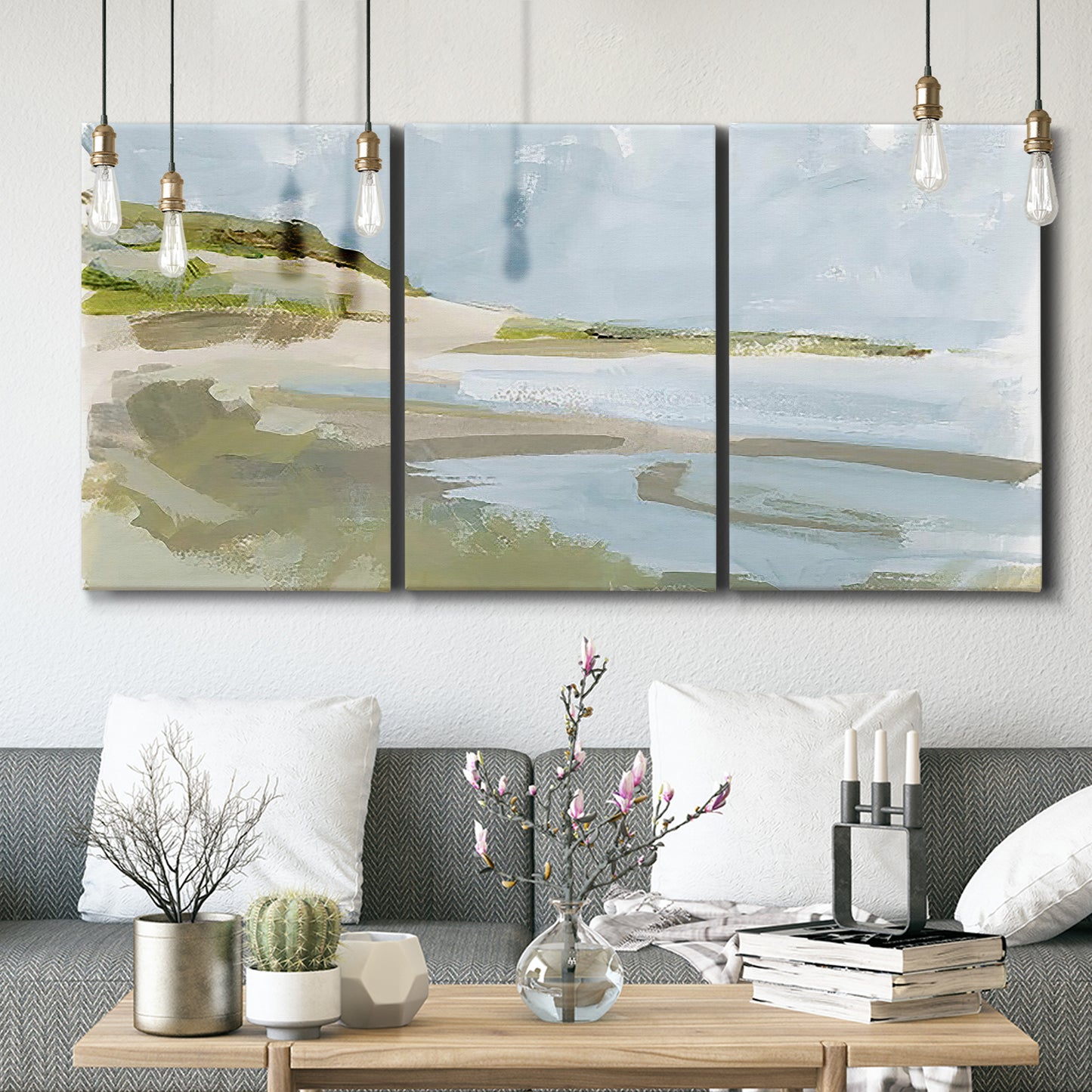 Three-panel canvas wall art featuring coastal cove with calm water, displayed in a modern living room above seating.