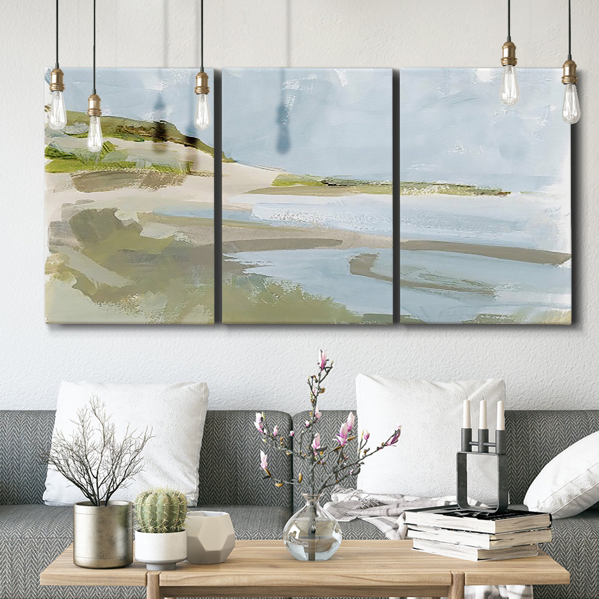 Three-panel canvas wall art featuring coastal cove with calm water, displayed in a modern living room above seating.