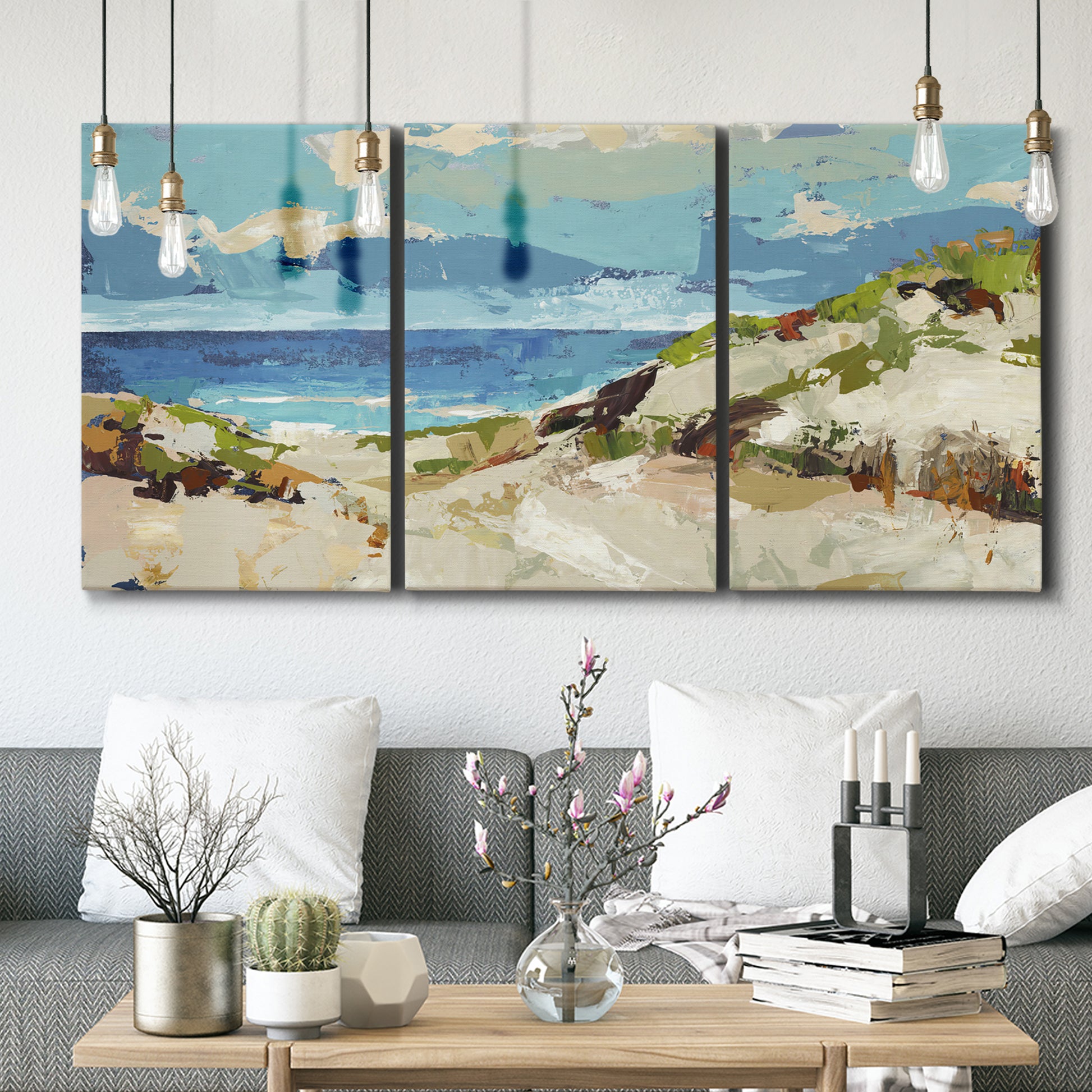 Three-panel canvas wall art featuring sand dunes beside open water, displayed in a modern living room above seating.