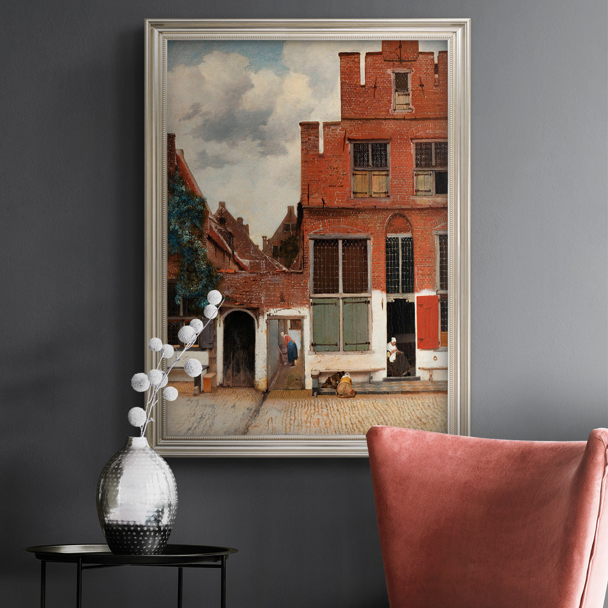 Realist city street scene by Johannes Vermeer in an ornate champagne frame displayed in a dark-toned interior setting.