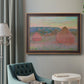 Impressionist haystack series landscape by Claude Monet in an ornate bronzed mahogany wood frame displayed in a neutral interior setting.