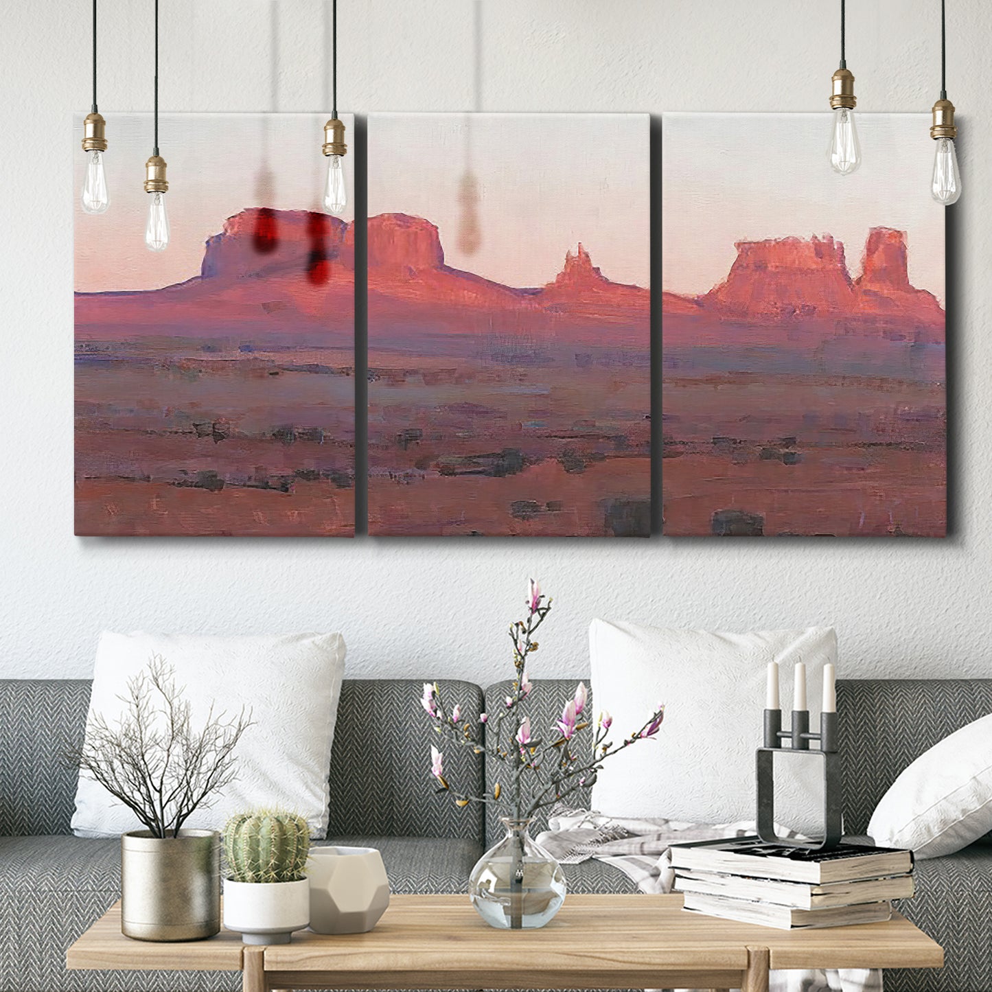 Three-panel canvas wall art featuring red rock desert formations at dusk, displayed in a modern living room above seating.