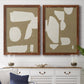 Set of two maple barnwood framed canvas prints depicting a coordinated art pair of irregular white cutout-like shapes on taupe grounds rendered as bold minimalist shape abstracts above a dining room sideboard.