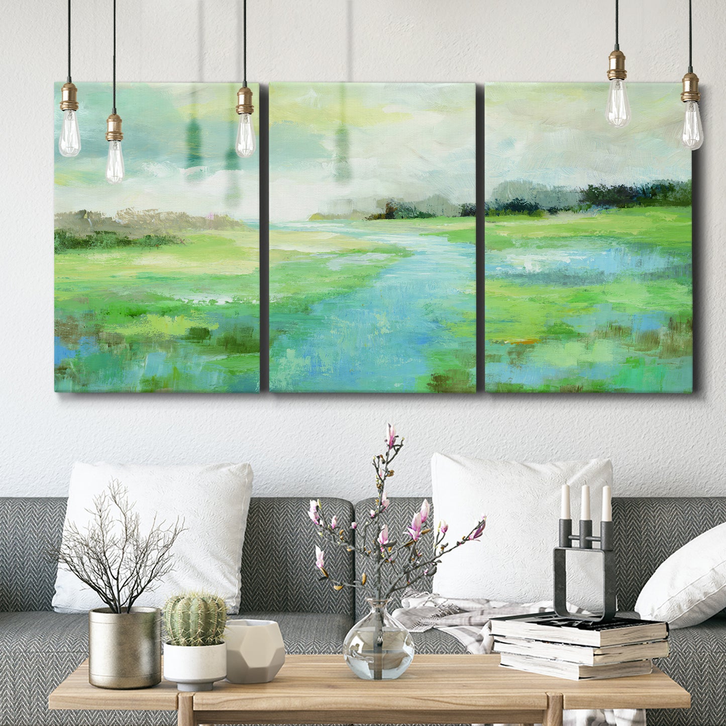 Three-panel canvas wall art featuring gentle stream winding through trees, displayed in a modern living room above seating.