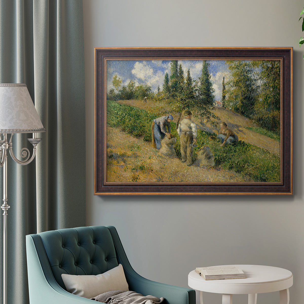 Impressionist countryside harvest scene by Camille Pissarro in an ornate bronzed mahogany wood frame displayed in a bright interior setting.