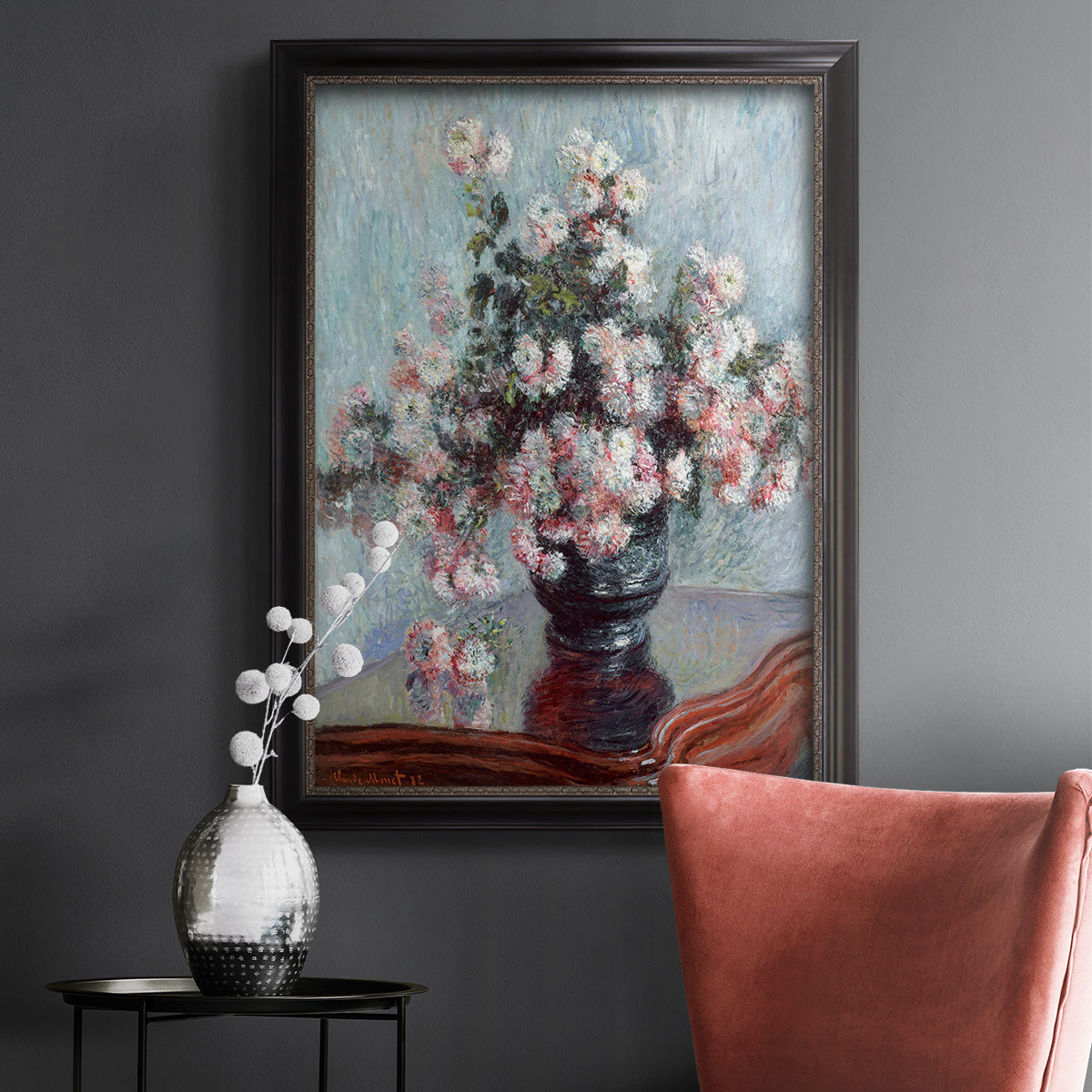 Impressionist chrysanthemum floral painting by Claude Monet in an ornate black frame with gilded inner detail displayed in a dark-toned interior setting.