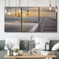 Three-panel canvas wall art featuring tropical beach at sunset photograph, displayed in a modern living room above seating.