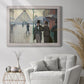 Impressionist urban street scene in the rain by Gustave Caillebotte in an ornate weathered white frame displayed in a bright interior setting.