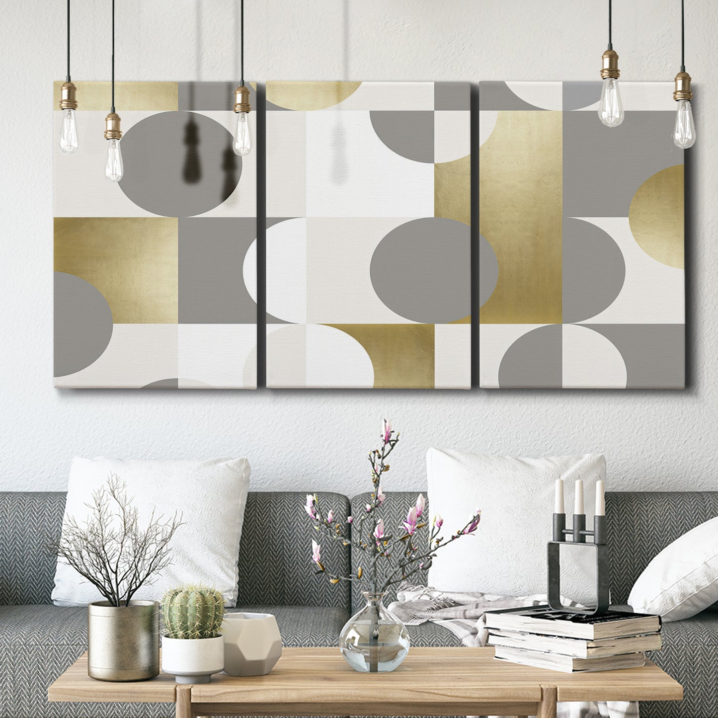 Three-panel canvas wall art featuring geometric gold abstract reflections, displayed in a modern living room above seating.