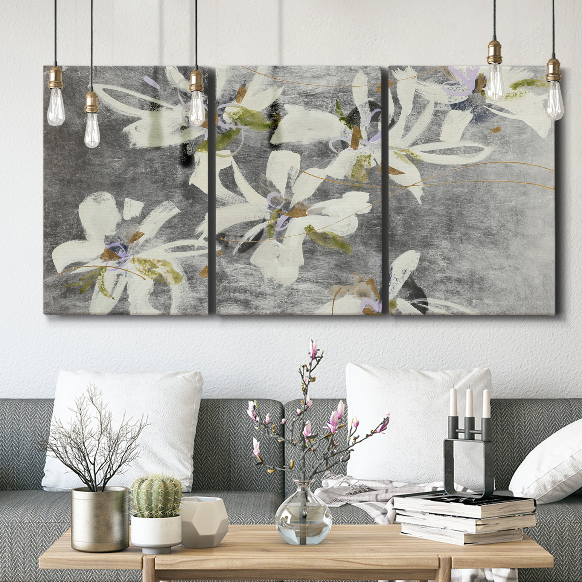Three-panel canvas wall art featuring delicate floral symbolic arrangement, displayed in a modern living room above seating.