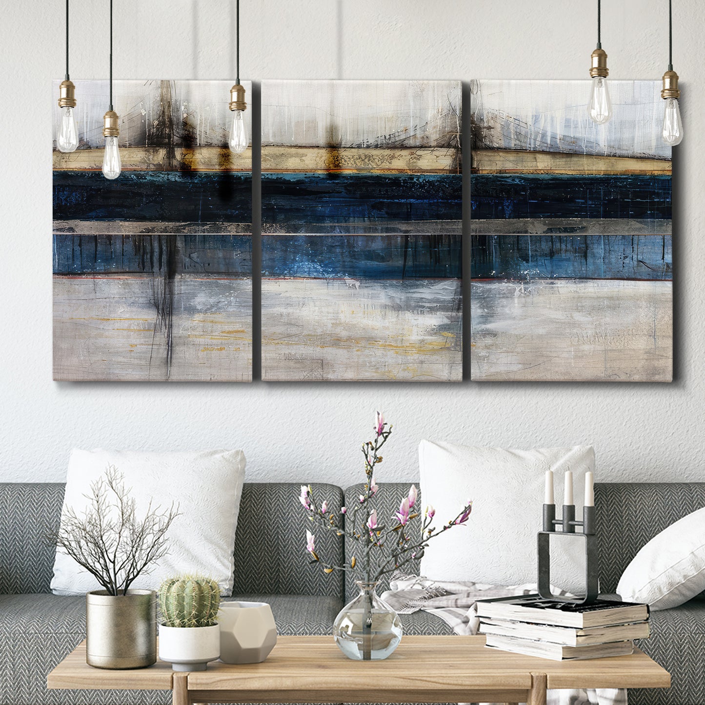 Three-panel canvas wall art featuring abstract blue urban composition, displayed in a modern living room above seating.