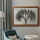 Vintage botanical plant study photograph by Karl Blossfeldt in an ornate vintage burl wood frame displayed in a neutral interior setting.