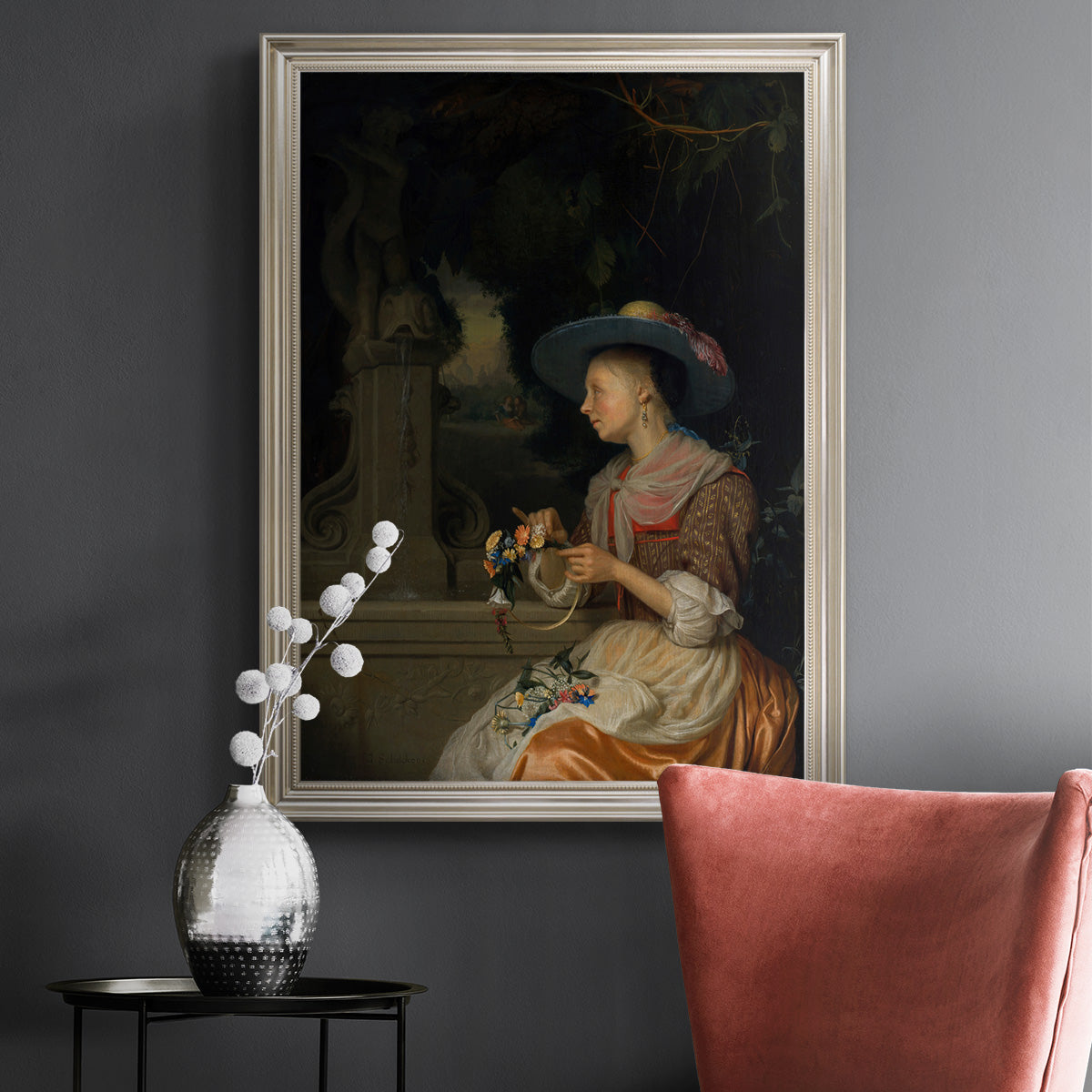 Classical interior scene of a woman weaving flowers by Godfried Schalcken in an ornate champagne frame displayed in a dark-toned interior setting.