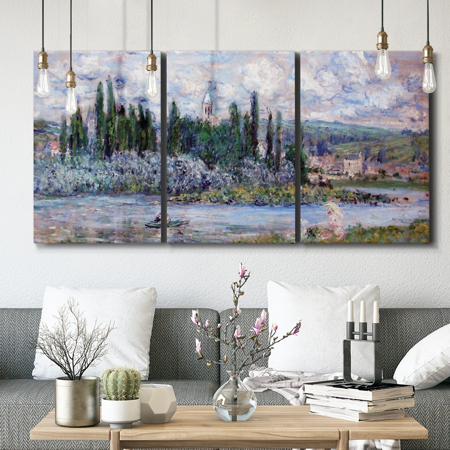 Three-panel canvas wall art featuring summer village view along river, displayed in a modern living room above seating.