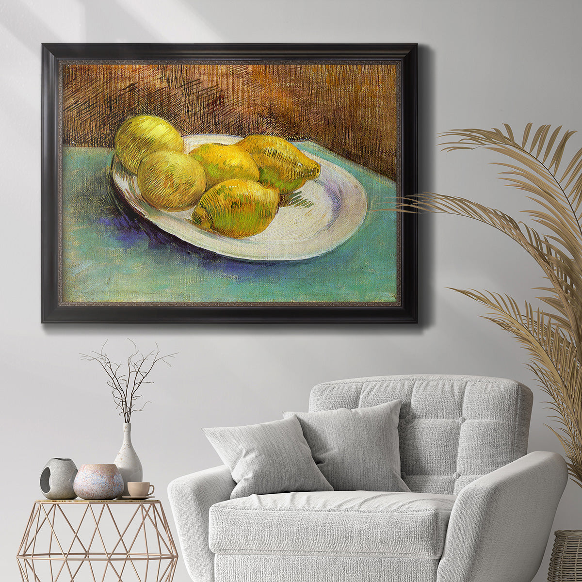 Impressionist still life with lemons by Vincent van Gogh in an ornate black frame with gilded inner detail displayed in a bright interior setting.
