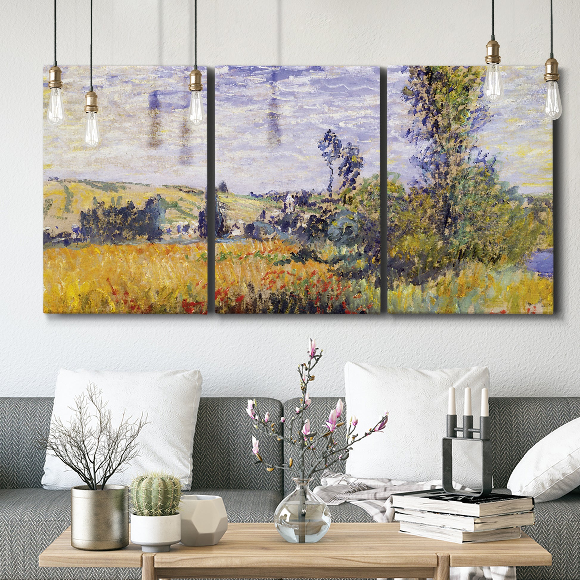 Three-panel canvas wall art featuring river village landscape with hills, displayed in a modern living room above seating.