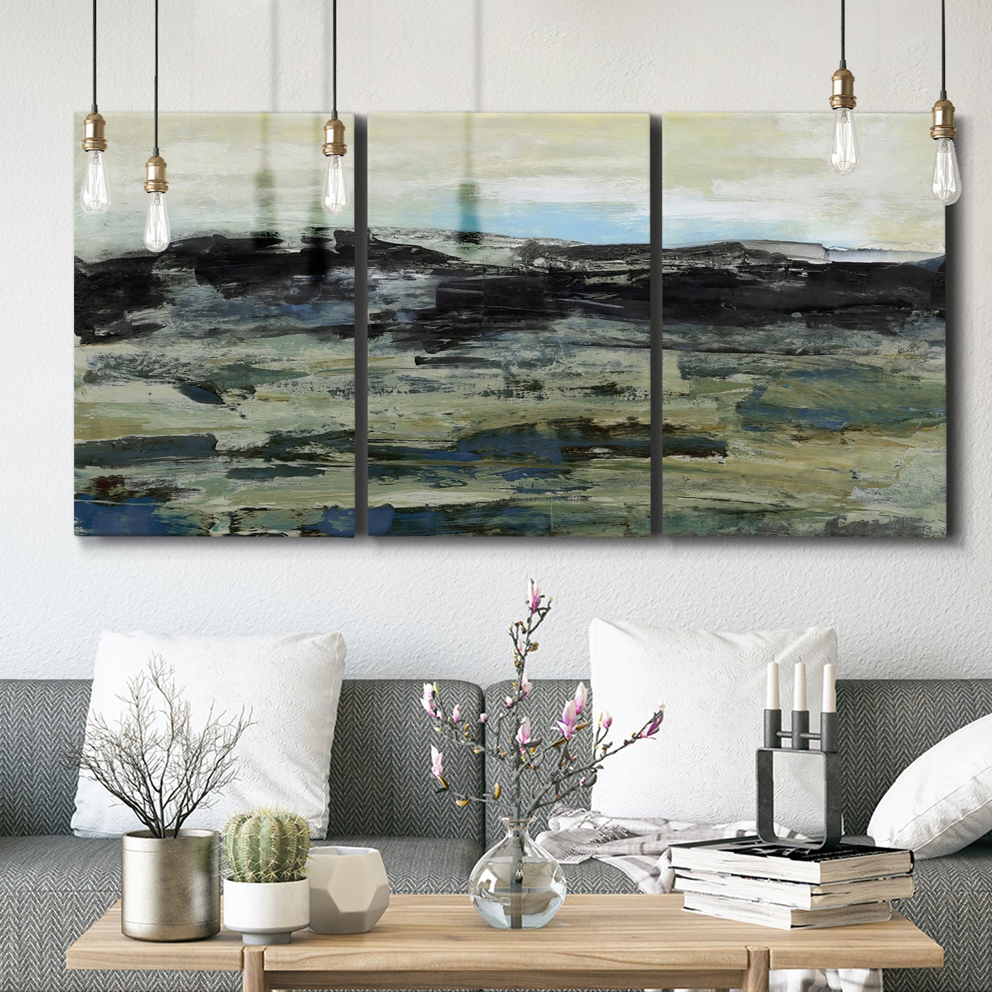 Three-panel canvas wall art featuring muted abstract landscape study, displayed in a modern living room above seating.