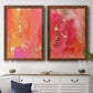 Set of two maple barnwood framed canvas prints depicting a coordinated art pair of luminous coral orange and pink color fields with gold flecks rendered as glamorous fluid abstracts above a dining room sideboard.