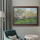 Impressionist spring orchard landscape by Vincent van Gogh in an ornate bronzed mahogany wood frame displayed in a bright interior setting.