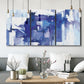 Three-panel canvas wall art featuring abstract urban street scene, displayed in a modern living room above seating.