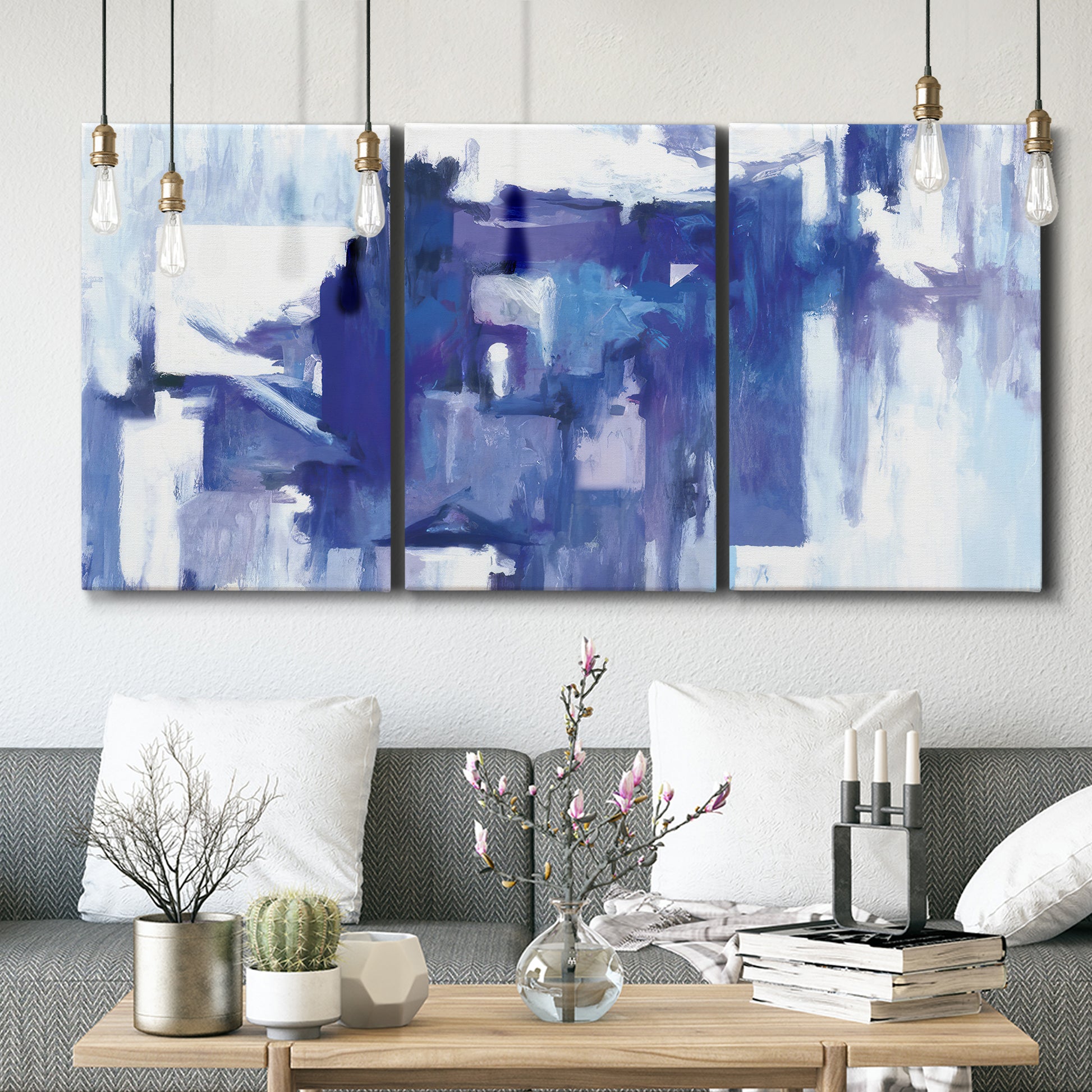 Three-panel canvas wall art featuring abstract urban street scene, displayed in a modern living room above seating.