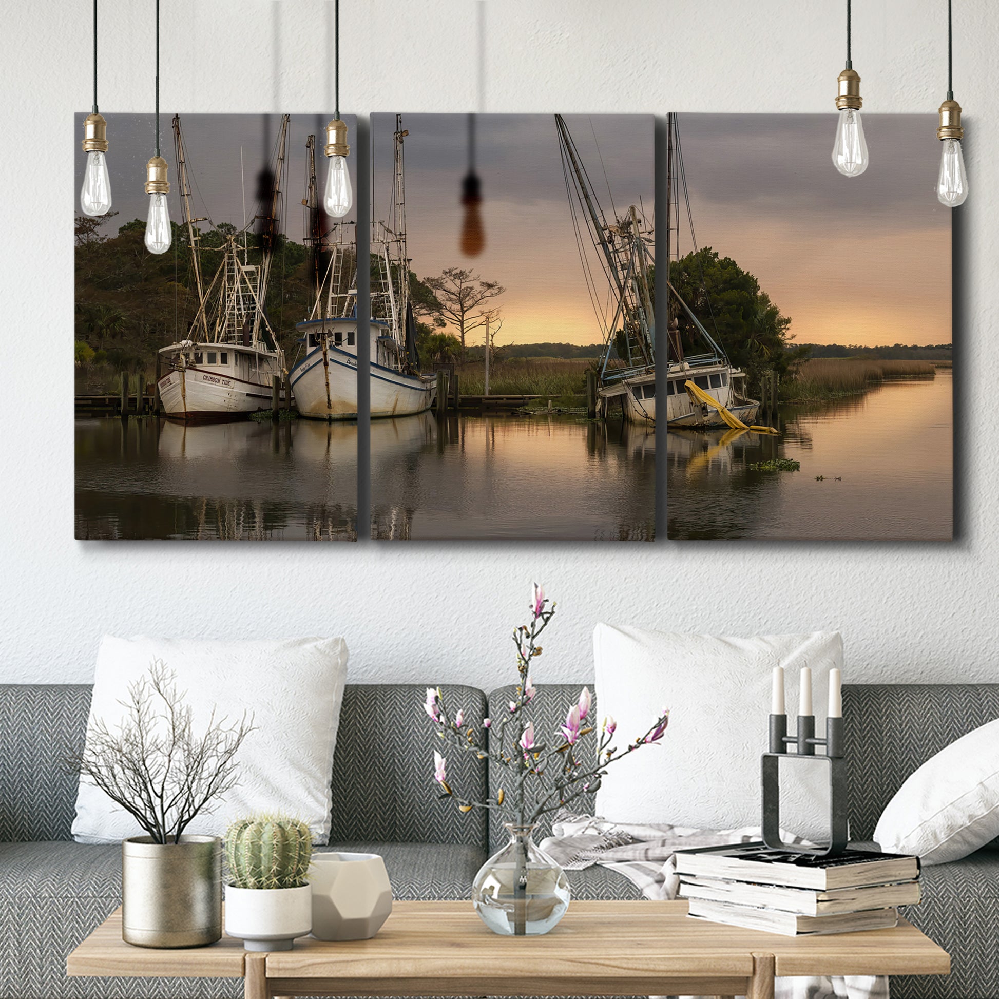 Three-panel canvas wall art featuring fishing trawlers on working harbor, displayed in a modern living room above seating.